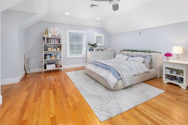 bedroom with baseboards, visible vents, light wood finished floors, and lofted ceiling