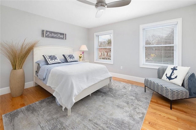 bedroom with baseboards, wood finished floors, and a ceiling fan