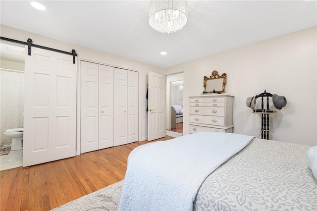 39 Greenbriar Rd, West Warwick, RI 02893 - bedroom with a barn door, wood finished floors, a closet, ensuite bathroom, and recessed lighting