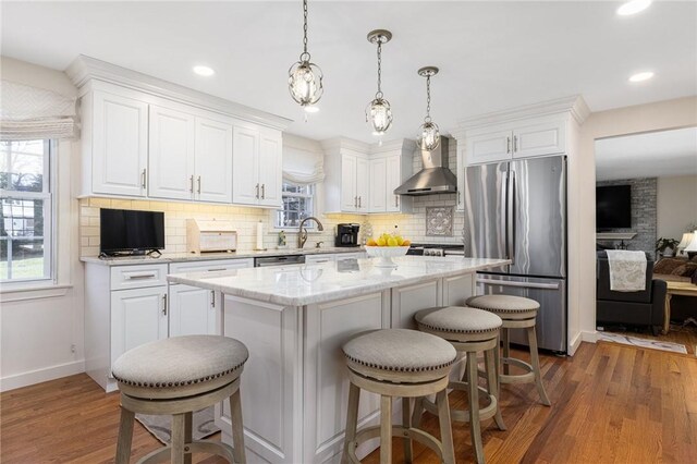 39 Greenbriar Rd, West Warwick, RI 02893 - kitchen with tasteful backsplash, appliances with stainless steel finishes, white cabinets, and wall chimney exhaust hood
