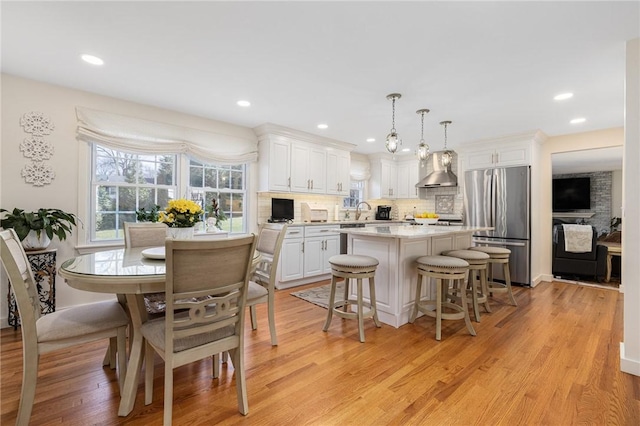 39 Greenbriar Rd, West Warwick, RI 02893 - kitchen with a kitchen bar, a center island, stainless steel refrigerator, light countertops, and white cabinets