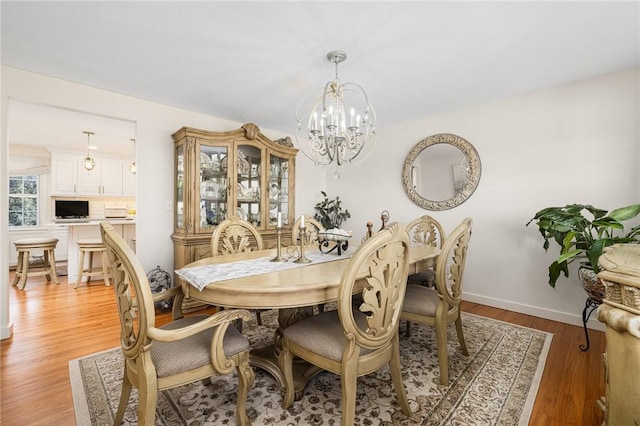39 Greenbriar Rd, West Warwick, RI 02893 - dining area with baseboards, light wood finished floors, and a chandelier