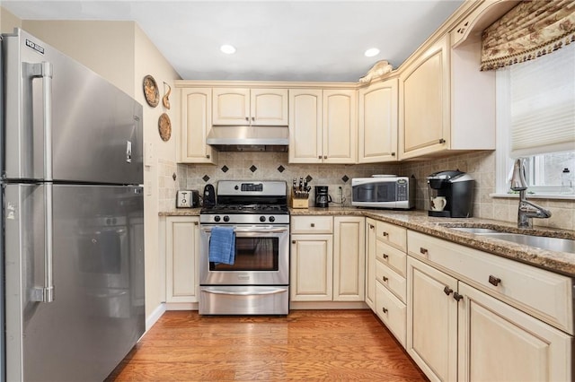 39 Greenbriar Rd, West Warwick, RI 02893 - kitchen with a sink, under cabinet range hood, cream cabinetry, and stainless steel appliances