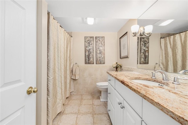 39 Greenbriar Rd, West Warwick, RI 02893 - bathroom featuring tile walls, wainscoting, vanity, toilet, and a notable chandelier