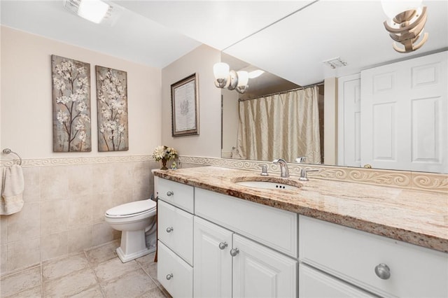 39 Greenbriar Rd, West Warwick, RI 02893 - full bathroom with wainscoting, vanity, toilet, tile patterned floors, and tile walls
