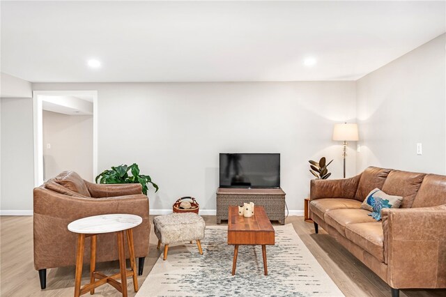 living area featuring light wood-style floors, baseboards, and recessed lighting
