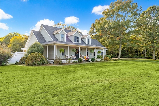 cape cod-style house with fence, a porch, roof with shingles, and a front yard