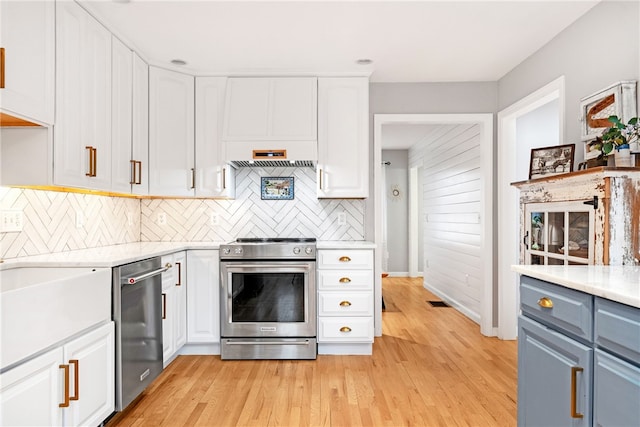 kitchen featuring white cabinets, stainless steel appliances, and backsplash