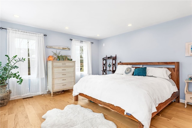 bedroom with light wood-style floors, recessed lighting, and access to outside