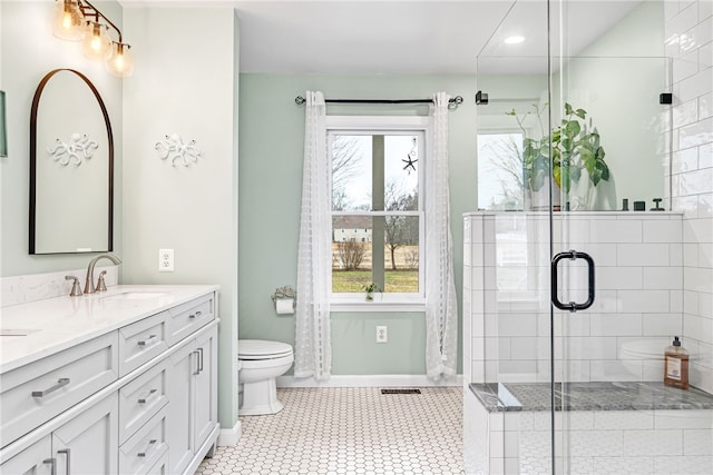 full bath with double vanity, toilet, a shower stall, and a sink