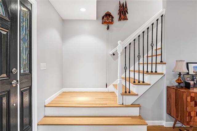 staircase with baseboards, recessed lighting, and wood finished floors