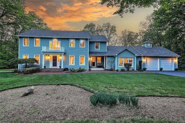 66 Tarklin Rd, Smithfield, RI 02814 - colonial house featuring an attached garage, asphalt driveway, a balcony, a front lawn, and covered porch