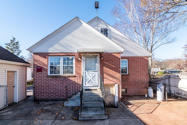back of property featuring brick siding and fence