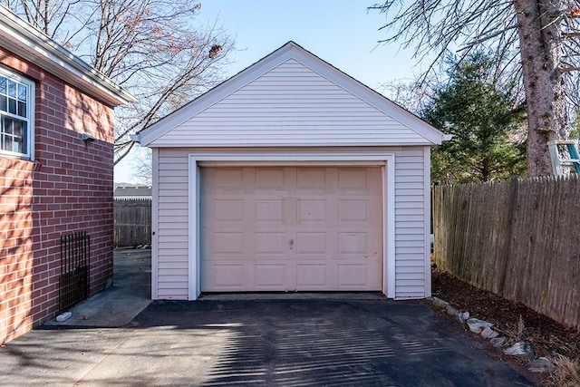 detached garage with fence and driveway