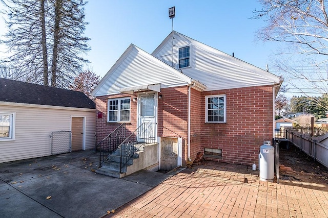 back of property with brick siding, a patio area, and fence