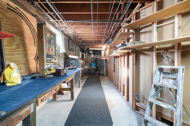 unfinished basement with a workshop area and heating fuel