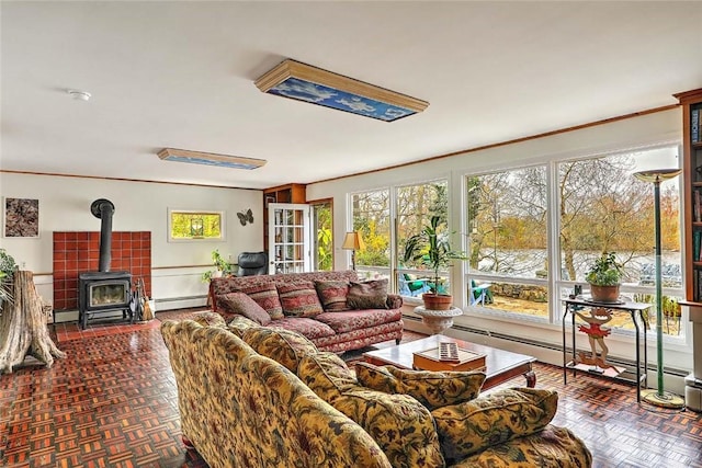 living area featuring crown molding, a baseboard heating unit, and a wood stove