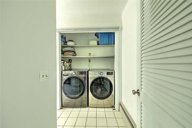 laundry area with washing machine and clothes dryer, laundry area, light tile patterned floors, and a baseboard radiator