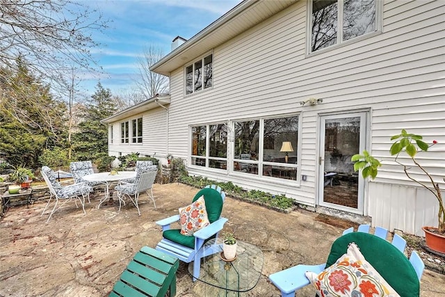 back of property featuring a patio and outdoor dining area
