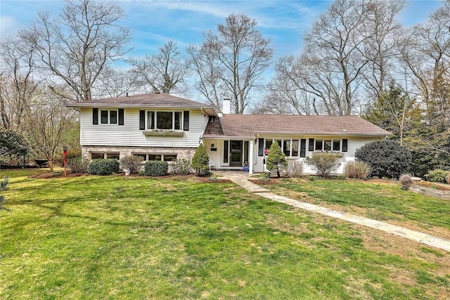 split level home with a chimney and a front yard