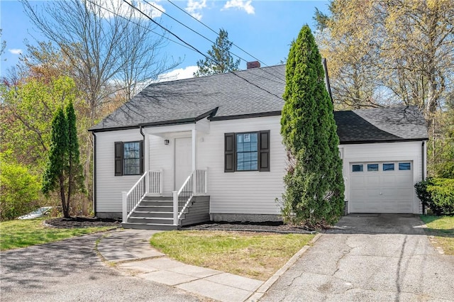 view of front of home featuring a shingled roof, a chimney, and driveway