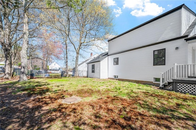 rear view of house with a yard and fence