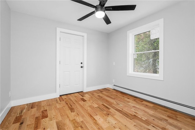 unfurnished room with baseboards, a baseboard radiator, a ceiling fan, and wood finished floors