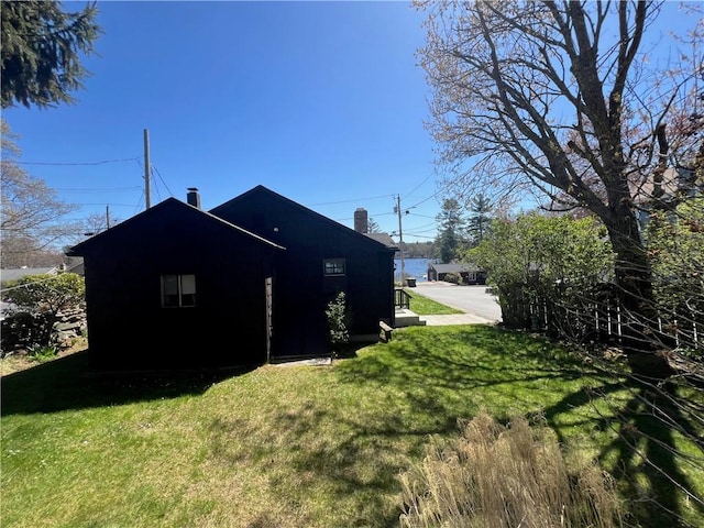 view of property exterior with a lawn and a chimney