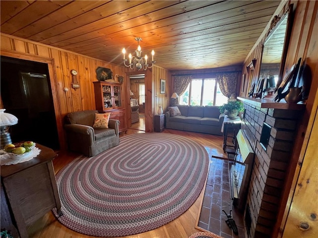 living room featuring wooden walls, an inviting chandelier, wooden ceiling, and wood finished floors