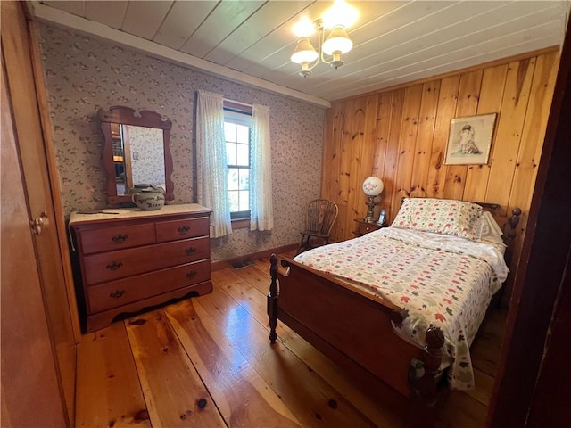 bedroom with wallpapered walls, ornamental molding, and light wood-style flooring