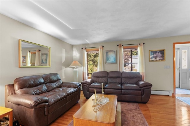 living room with a baseboard heating unit and wood finished floors