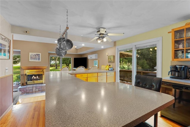 interior space with ceiling fan and a glass covered fireplace
