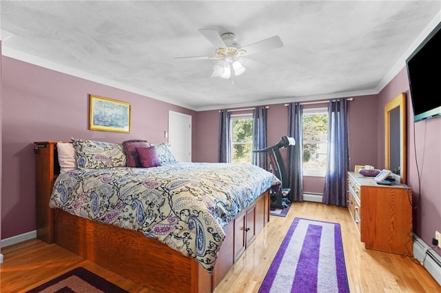 bedroom featuring crown molding, a baseboard radiator, light wood-type flooring, and ceiling fan