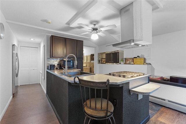 kitchen featuring island range hood, appliances with stainless steel finishes, a baseboard radiator, a peninsula, and dark wood-type flooring