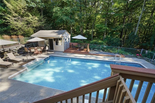 view of pool featuring fence, a fenced in pool, outdoor dining space, and an outbuilding