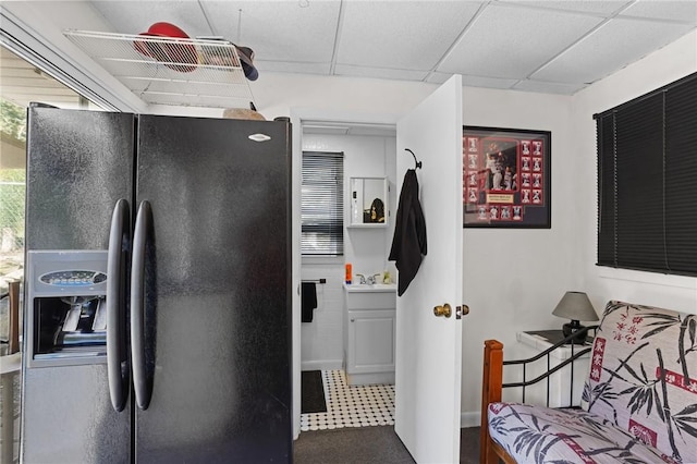 kitchen with black refrigerator with ice dispenser and a sink