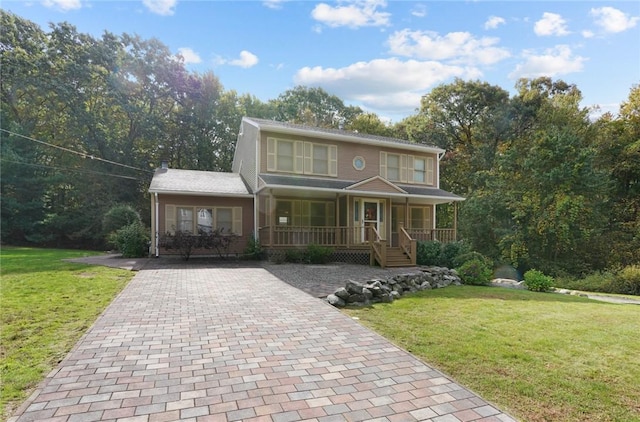 view of front of property with a porch, decorative driveway, and a front lawn