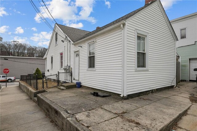 752 Social St, Woonsocket, RI 02895 - view of home's exterior with fence, a chimney, a gate, and roof with shingles