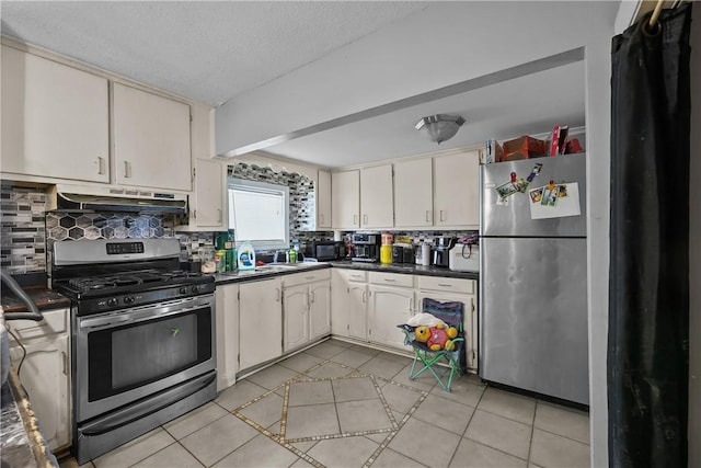 752 Social St, Woonsocket, RI 02895 - kitchen featuring light tile patterned flooring, dark countertops, stainless steel appliances, tasteful backsplash, and under cabinet range hood