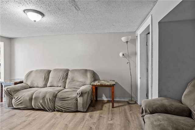 752 Social St, Woonsocket, RI 02895 - living room with baseboards, a textured ceiling, and wood finished floors