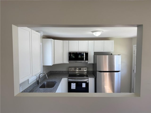 26 Yale Ave, East Providence, RI 02915 - kitchen with a sink, dark countertops, white cabinets, and stainless steel appliances