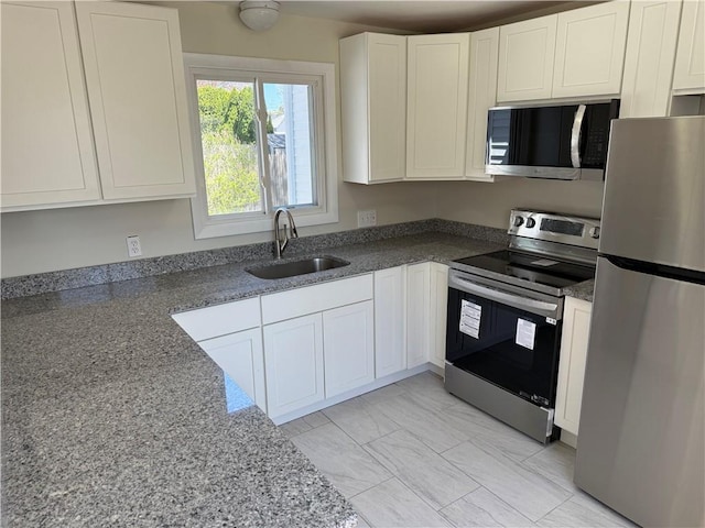 26 Yale Ave, East Providence, RI 02915 - kitchen featuring a sink, white cabinetry, dark stone countertops, and stainless steel appliances