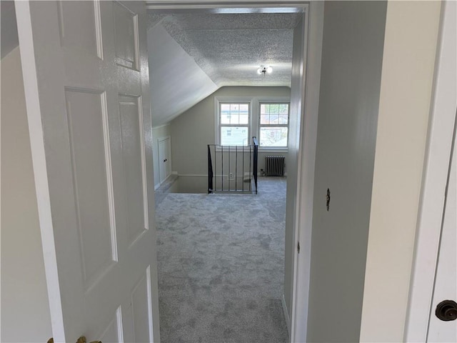 bonus room with carpet floors, radiator, lofted ceiling, baseboards, and a textured ceiling