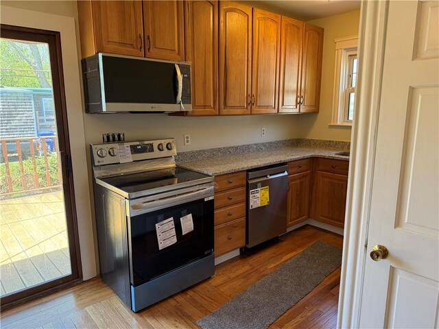 29 Lindy Ave, East Providence, RI 02915 - kitchen with brown cabinetry, light wood-style flooring, and appliances with stainless steel finishes
