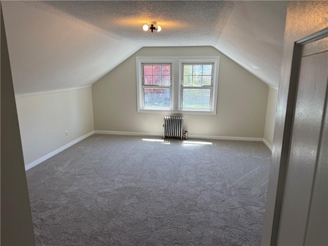 bonus room featuring radiator, baseboards, carpet flooring, and lofted ceiling