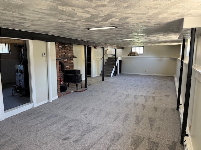 basement with stairway, carpet, and a wood stove
