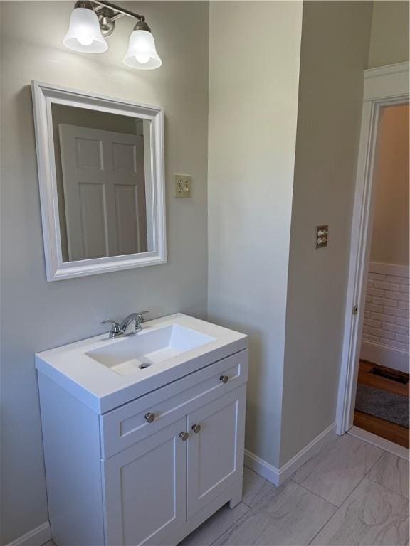bathroom featuring vanity, baseboards, and marble finish floor