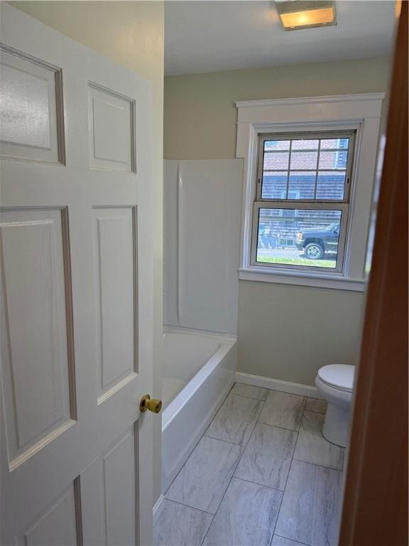 bathroom featuring toilet, baseboards, and marble finish floor