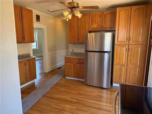 29 Lindy Ave, East Providence, RI 02915 - kitchen featuring freestanding refrigerator, crown molding, brown cabinetry, and light wood-type flooring