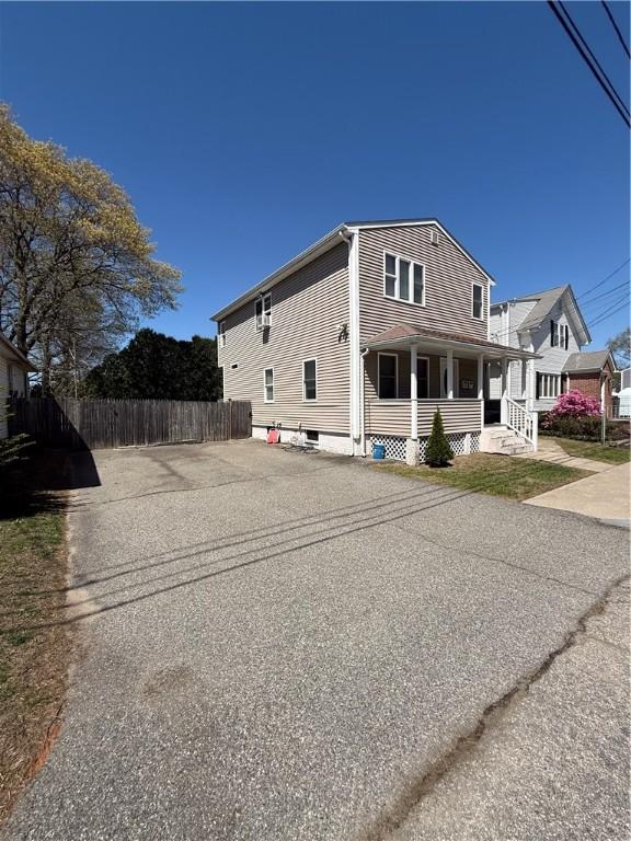 view of property exterior featuring a porch and fence